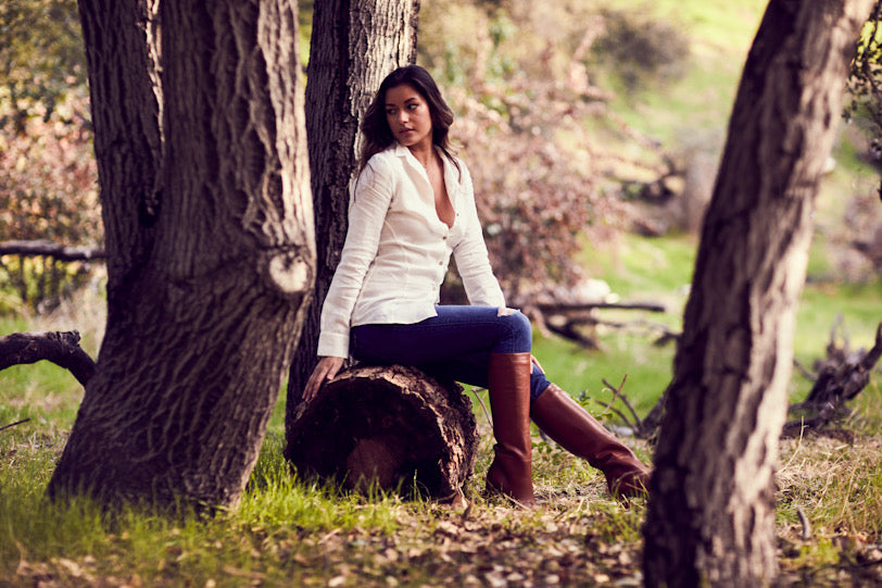 Woman sitting on a log in a forest setting
